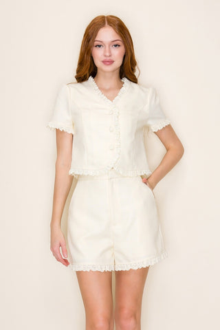 Woman wearing a pale yellow outfit against a plain background