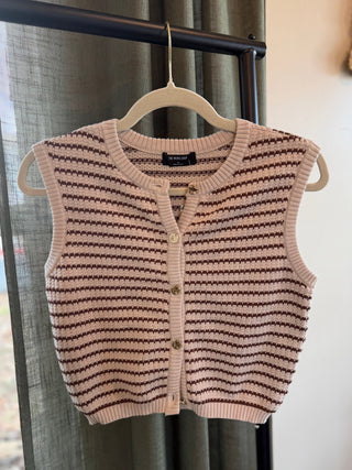 Striped knitted vest hanging on a hanger against a neutral background