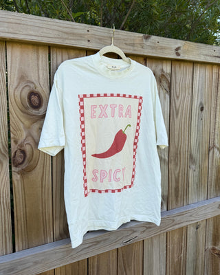 White t-shirt with red chili pepper graphic and 'Extra Spicy' text on a wooden fence.